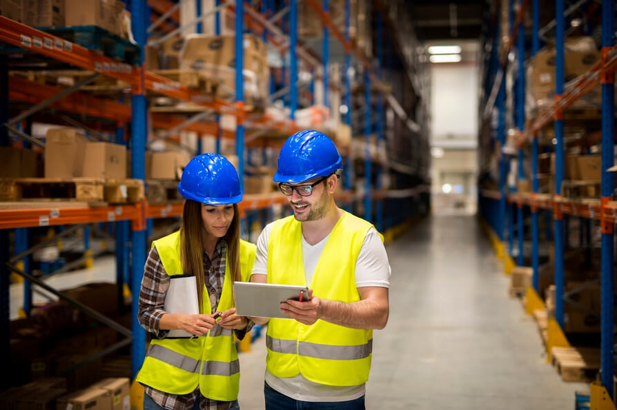Workers in a large distribution warehouse discussing